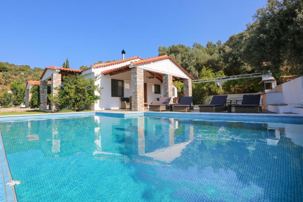 eine Villa mit einem Pool und einem Haus in der Unterkunft Skiathos Island Villas in Skiathos-Stadt