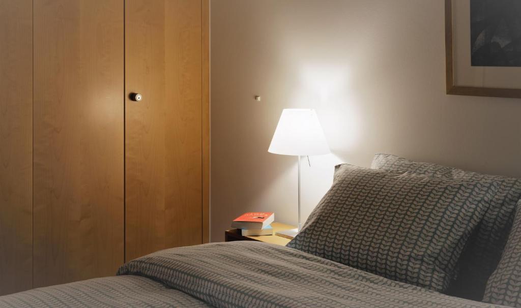 a bedroom with a bed and a lamp on a night stand at Haus-Ascot-Zermatt in Zermatt