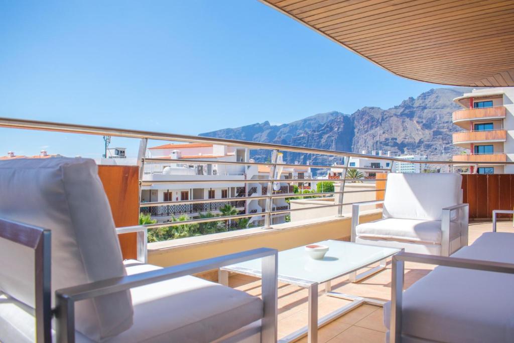 a balcony with chairs and a table and a view at Large terrace with views on the cliffs at Balcon De Los Gigantes in Puerto de Santiago