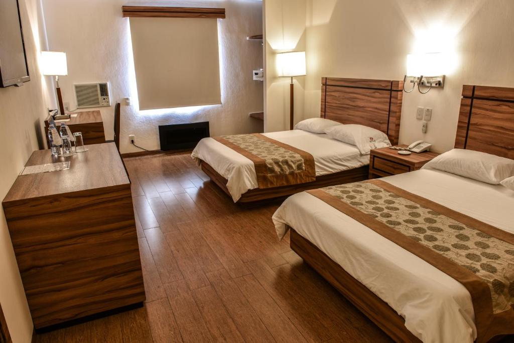 a hotel room with two beds and a bathroom at Hotel Oliver Inn - Business Class in Querétaro