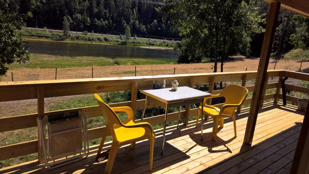 einen Tisch und Stühle auf einer Terrasse mit Flussblick in der Unterkunft Eikheim in Birkeland