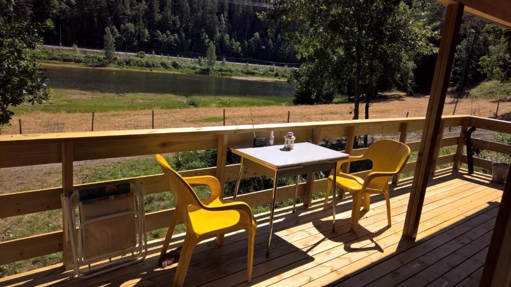 a table and chairs on a deck with a view of a river at Eikheim in Birkeland