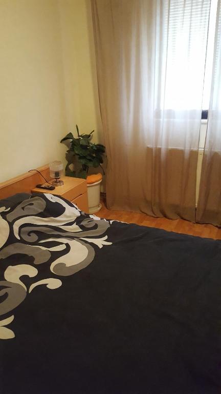 a bedroom with a bed with a black and white blanket at Apartment Valea Azugii in Azuga