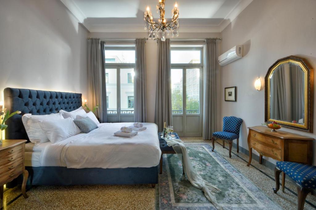 a bedroom with a bed and a mirror and a table at Athenian Vintage Apartments in Athens