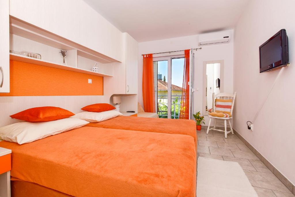 a bedroom with two beds and a television in it at Mandalena in Gradac