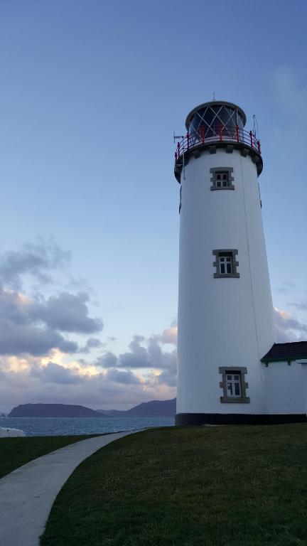 レタケニーにあるFanad Lighthouseの緑の草原の上に座る灯台
