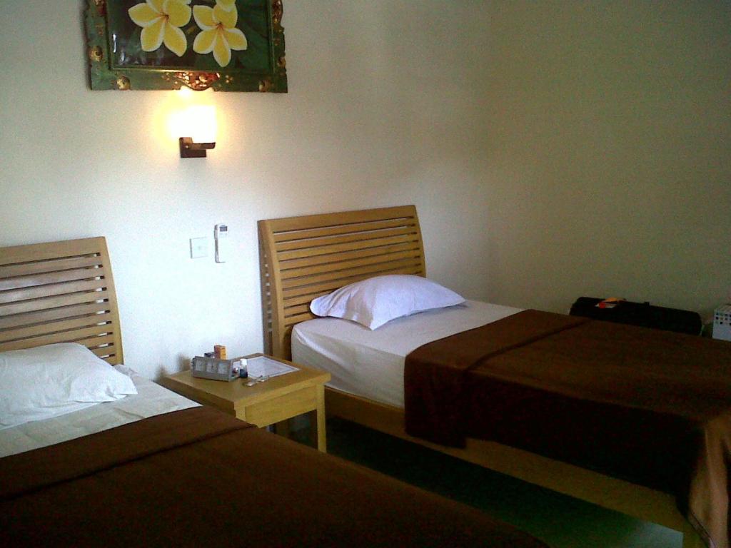 Kirana Home Stay في سانور: غرفة فندقية بسريرين وطاولة