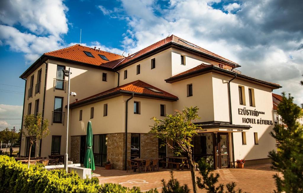 a large white building with a red roof at Ezüsthíd Hotel in Veszprém