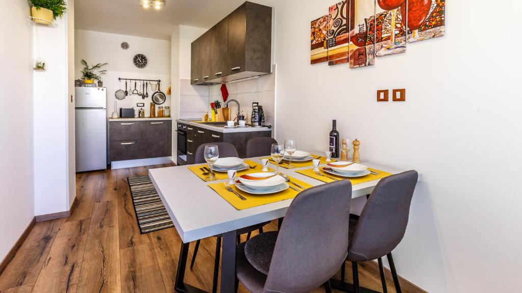 kuchnia i jadalnia ze stołem i krzesłami w obiekcie Apartment Arnold w mieście Rijeka