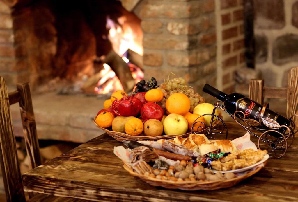 a table with two baskets of fruit and a fireplace at Marani Boutique Hotel in Tbilisi City