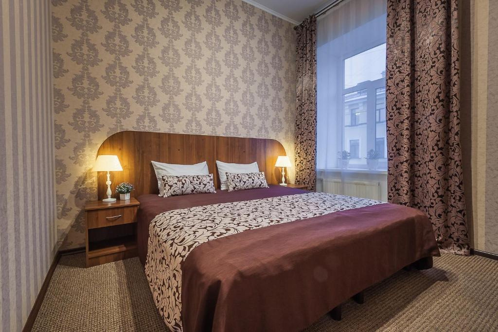 ein Schlafzimmer mit einem großen Bett und einem Fenster in der Unterkunft Blues in Sankt Petersburg