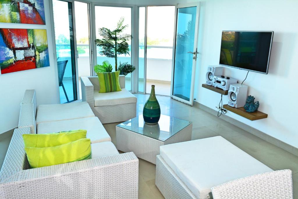 Torres del Lago Apartamentos في كارتاهينا دي اندياس: غرفة معيشة بأثاث أبيض وتلفزيون