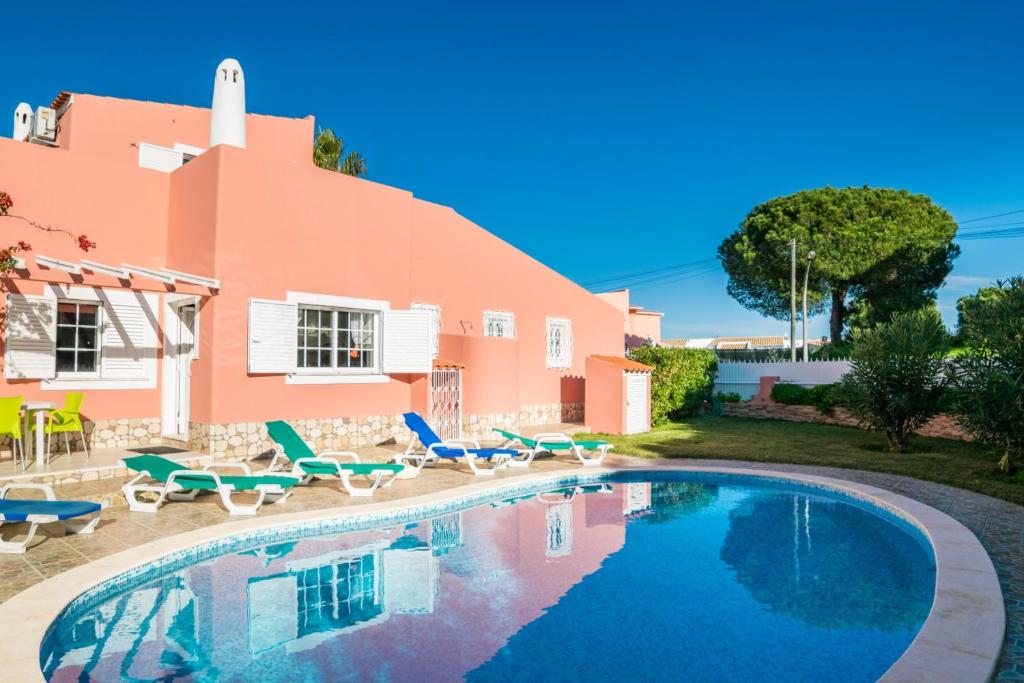 a villa with a swimming pool in front of a house at Villa Paraiso Spacious and Central To enjoy best beaches AC WIFI GARDEN POOL in Albufeira