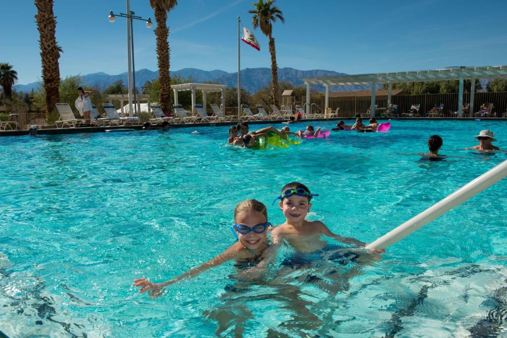 two boys in the swimming pool at a resort at The Ranch At Death Valley in Indian Village