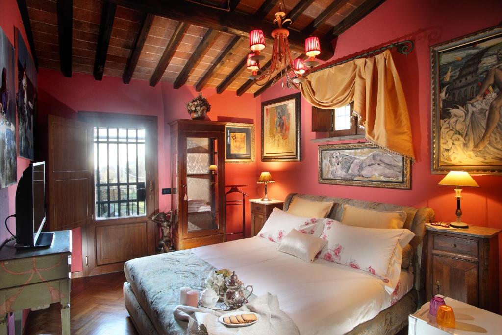 a bedroom with a large bed with red walls at Camera Rosa in Borgo a Buggiano