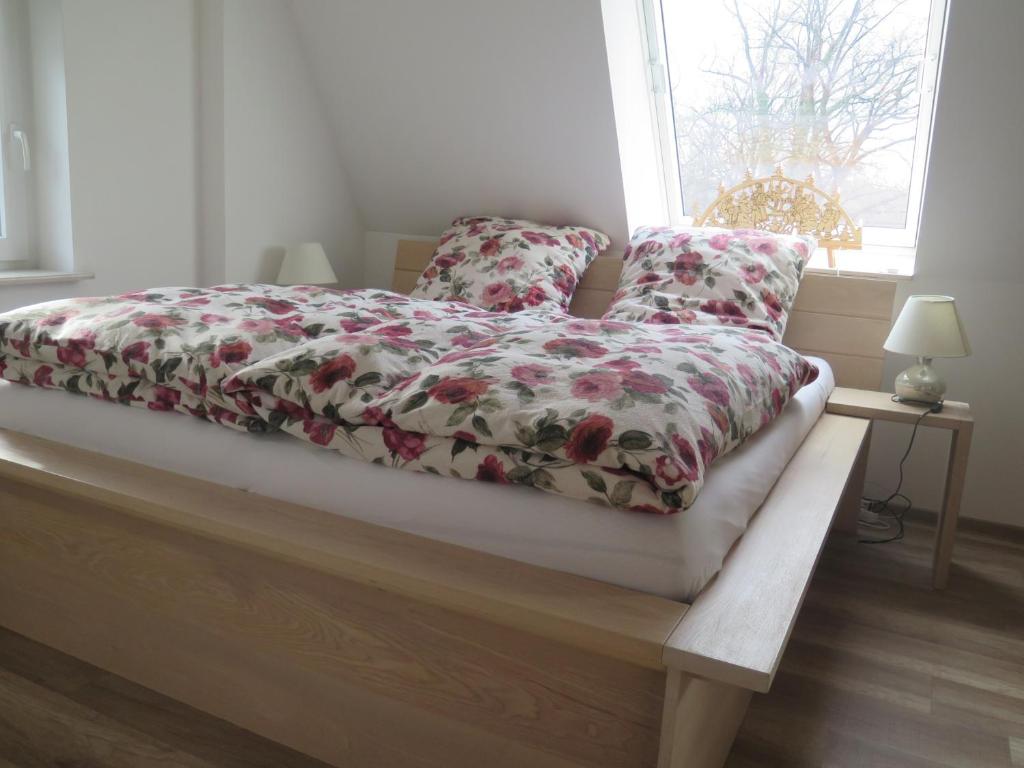 a bed with a floral comforter and two pillows at CrossARTig in Zwickau