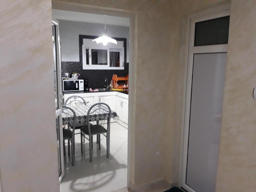 - une cuisine et une salle à manger avec une table et des chaises dans l'établissement Appartement Akid Lotfi Oran, à Oran