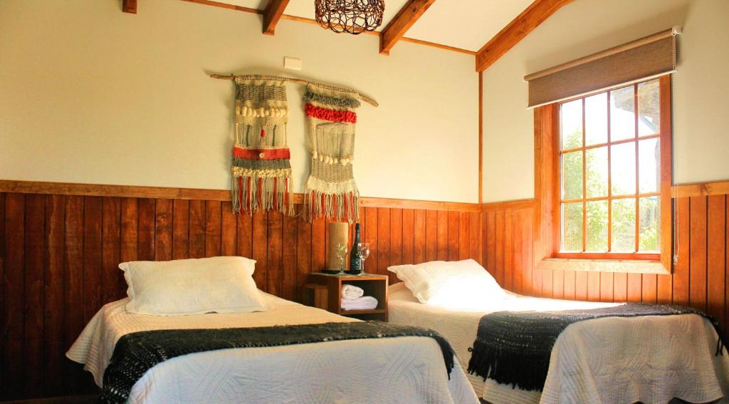 a bedroom with two beds and a window at Dorotea Vista in Puerto Natales