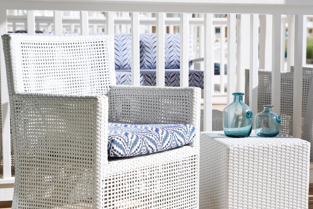 a white wicker chair with two blue glass vases on a table at Isla Bella Beach Resort & Spa - Florida Keys in Marathon