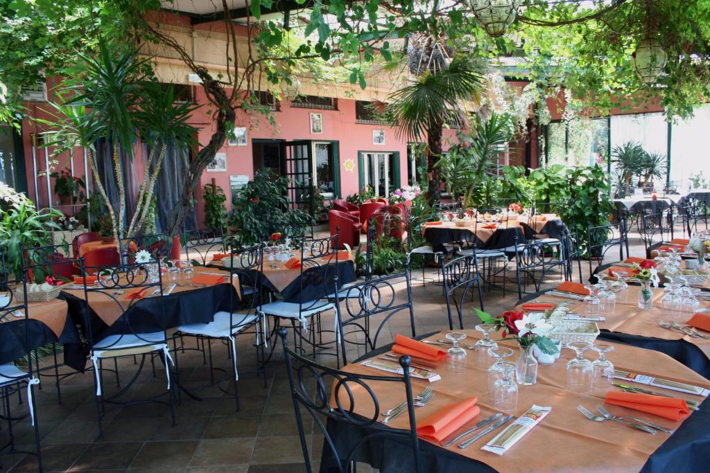a restaurant with tables and chairs in a courtyard at Hotel 5 Terre Nel Sole in Deiva Marina