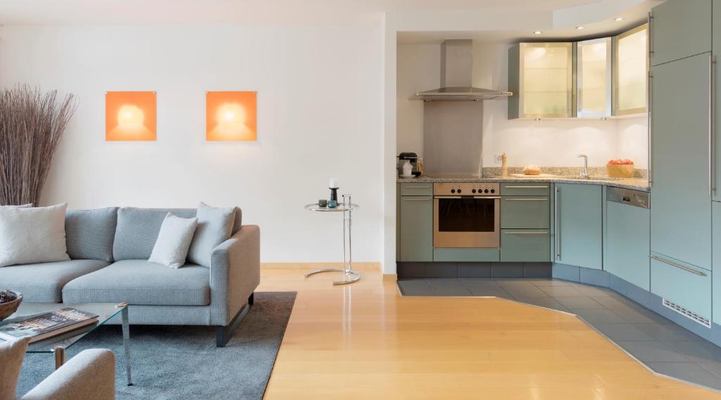 a living room with a couch and a kitchen at Haus-Ascot-Zermatt in Zermatt
