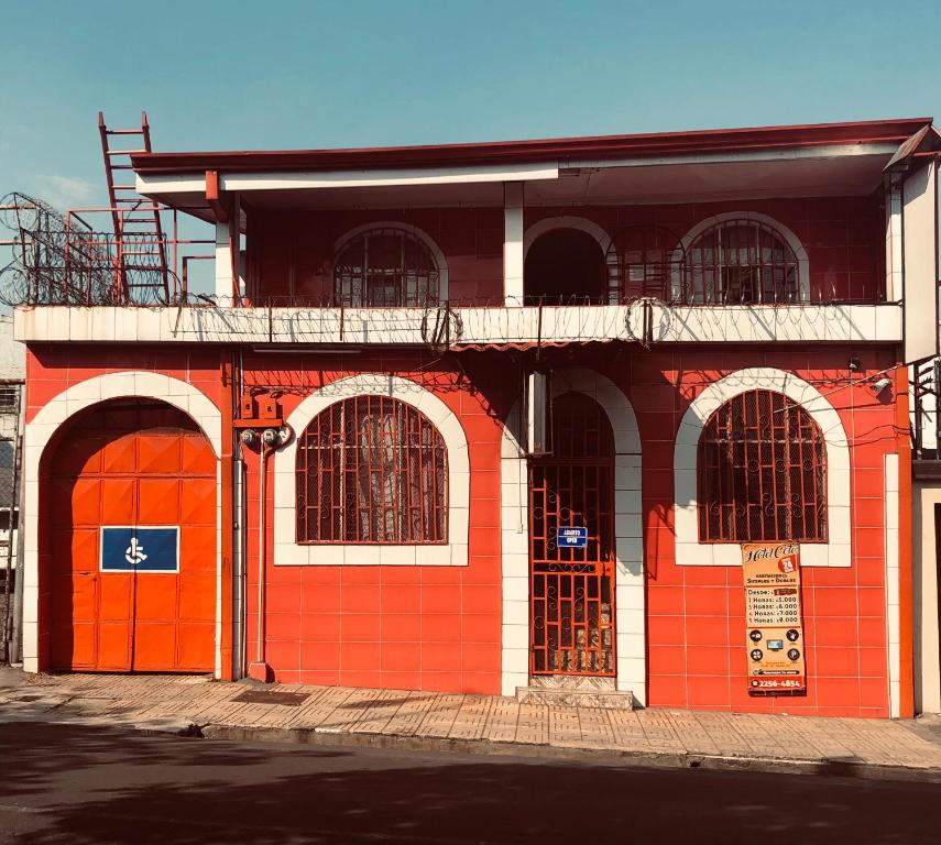 un edificio naranja y blanco con puertas rojas en Hotel Coto, en San José