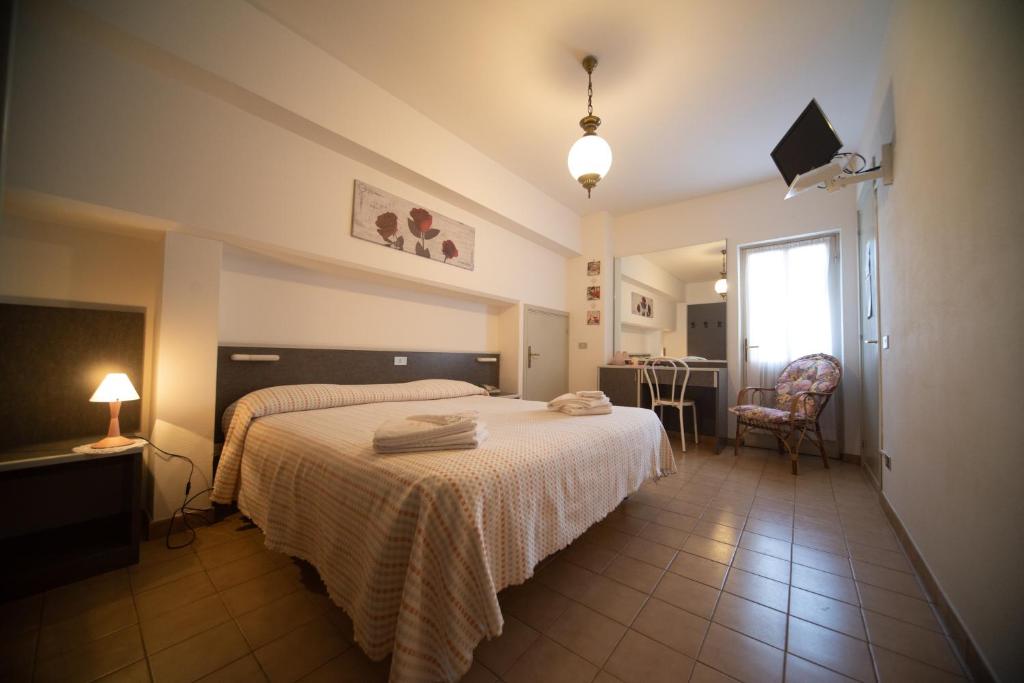 ein Schlafzimmer mit einem Bett, einem Tisch und einem Stuhl in der Unterkunft Miramonti in Calizzano