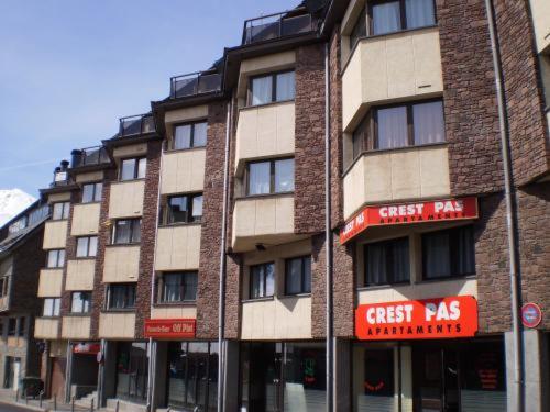 a tall brick building with red signs on it at Apartaments Crest Pas in Pas de la Casa