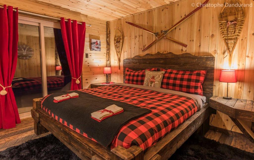 a bedroom with a bed in a log cabin at Le Trappeur - Les Chalets Spa Canada in La Malbaie