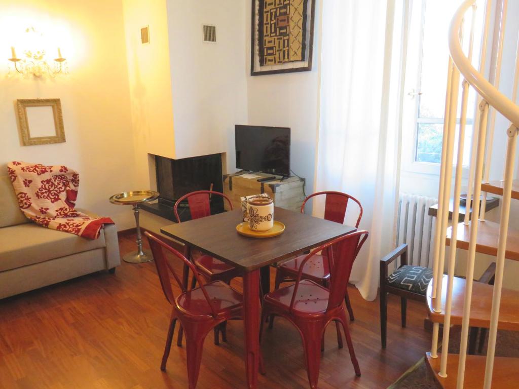 ein Wohnzimmer mit einem Tisch und roten Stühlen in der Unterkunft Emozione Bologna Sant Orsola in Bologna