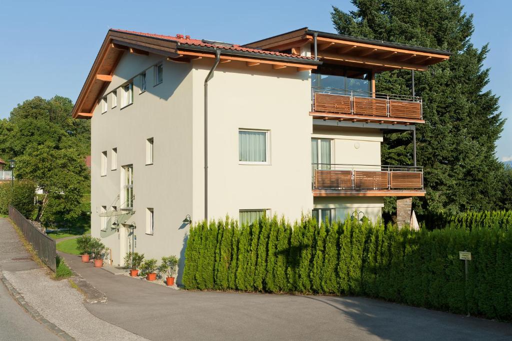 a white building with a balcony on the side of a road at Apartments Hauskaernten in Velden am Wörthersee