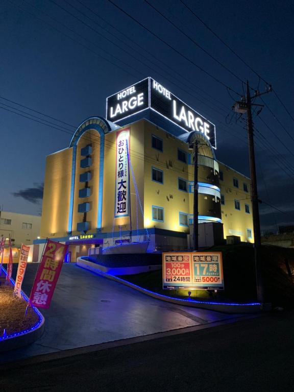 un gran edificio con letreros de neón delante de él en Hotel Large (Adult Only), en Honjo