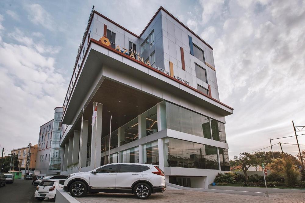 um carro branco estacionado em frente a um edifício em The Azana Hotel Airport Semarang em Semarang