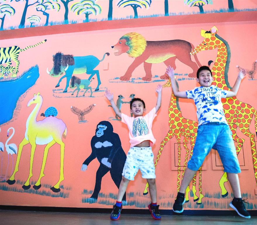 two children standing in front of a wall with animals at Leofoo Resort Guanshi in Guanxi