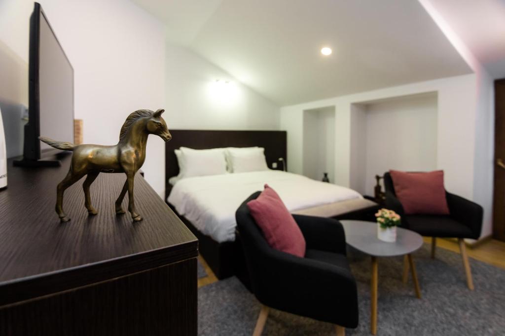een slaapkamer met een bed en een standbeeld van een paard op een dressoir bij VovaDoma in Tbilisi City
