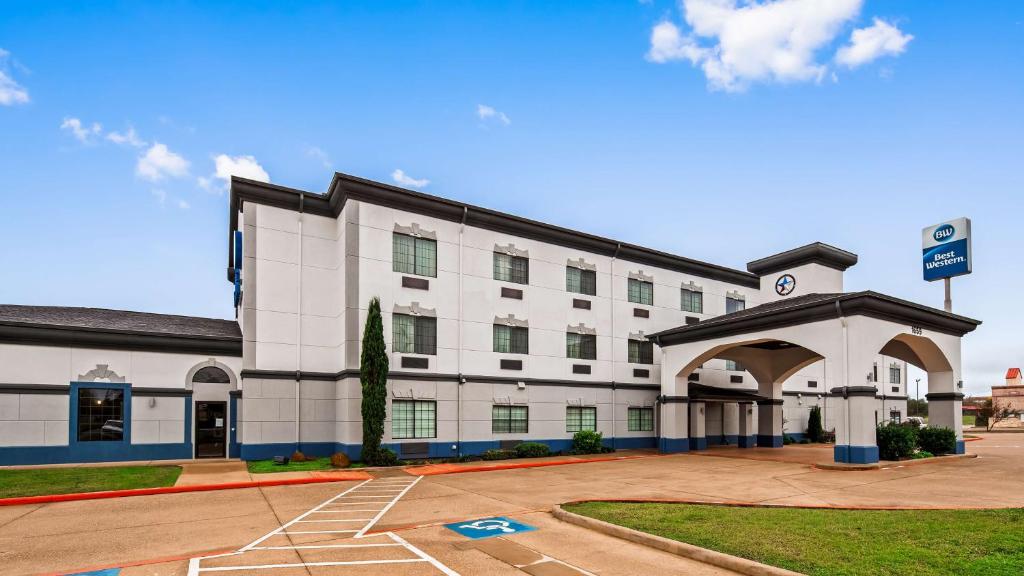 un gran edificio blanco con un aparcamiento enfrente en Best Western Jacksonville Inn, en Jacksonville