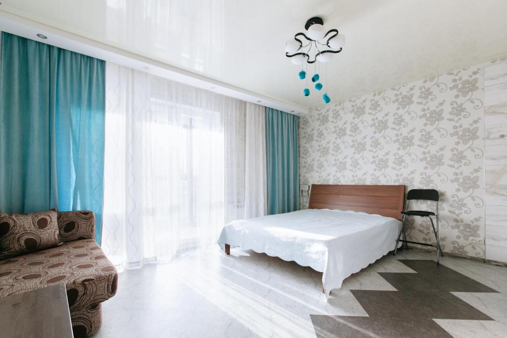 ノヴォシビルスクにあるApartamenty Svetlica Shamshinykh 90/5 studioのベッドルーム(ベッド1台、ソファ付)