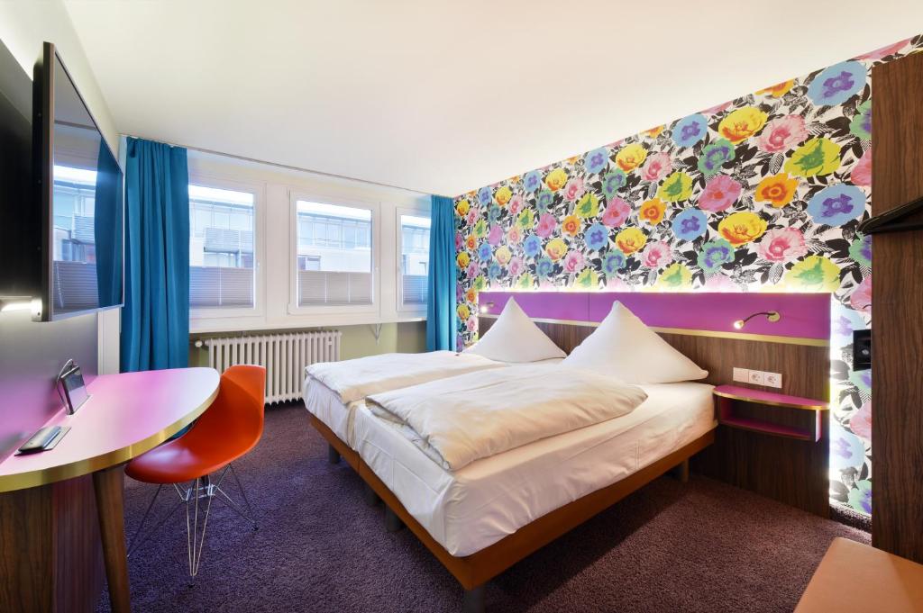 a bedroom with a bed and a desk and a table at Cityhotel Thüringer Hof new CLASSIC - Self Check-In in Hannover