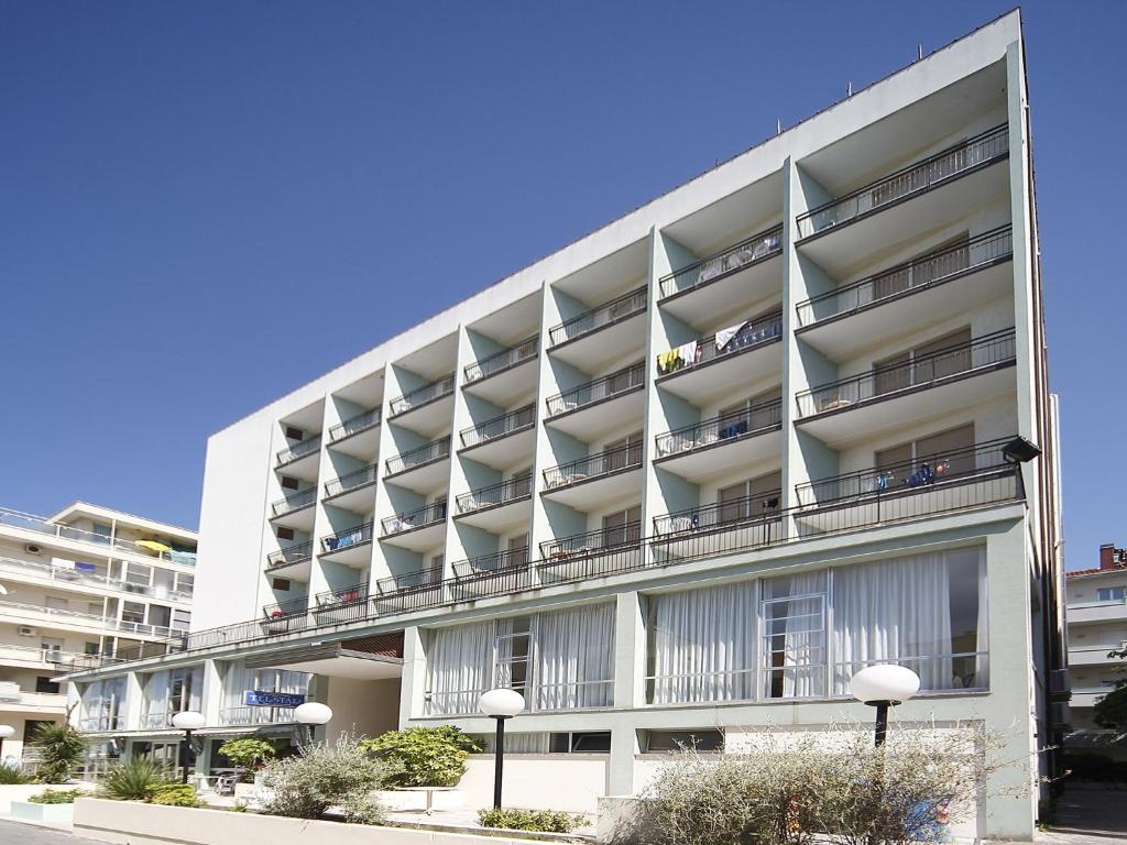 un immeuble d'appartements avec balcon sur le côté. dans l'établissement Hotel Telstar, à Rimini
