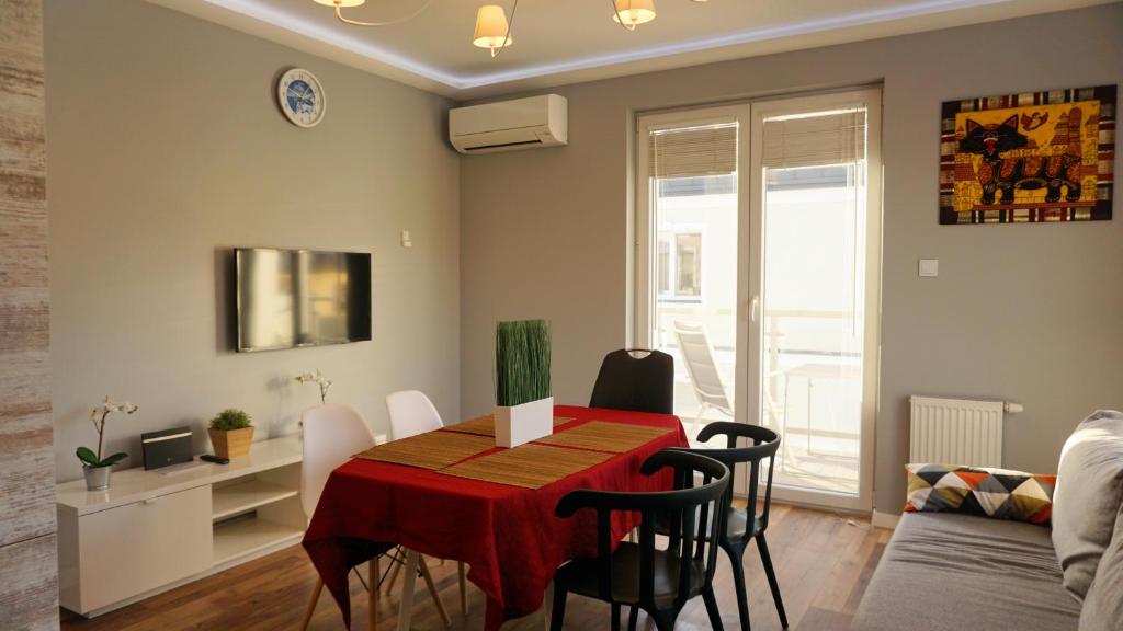 a dining room and living room with a table and chairs at Apartament Lublin Centrum "Foxy Cat" in Lublin