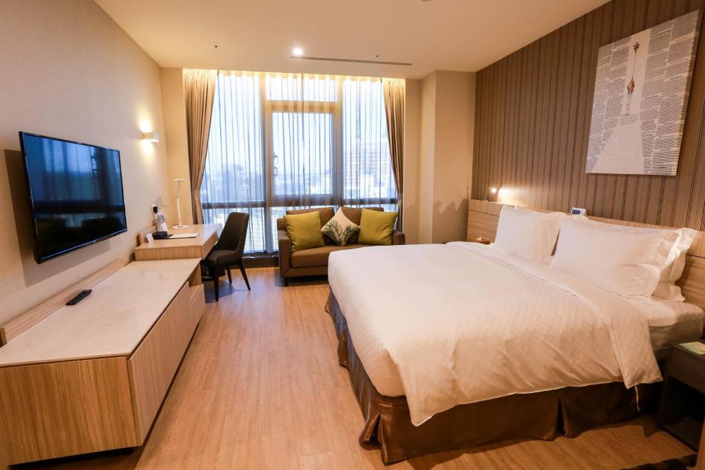 um quarto de hotel com uma cama e uma televisão de ecrã plano em AJ Hotel Hsinchu em Zhubei