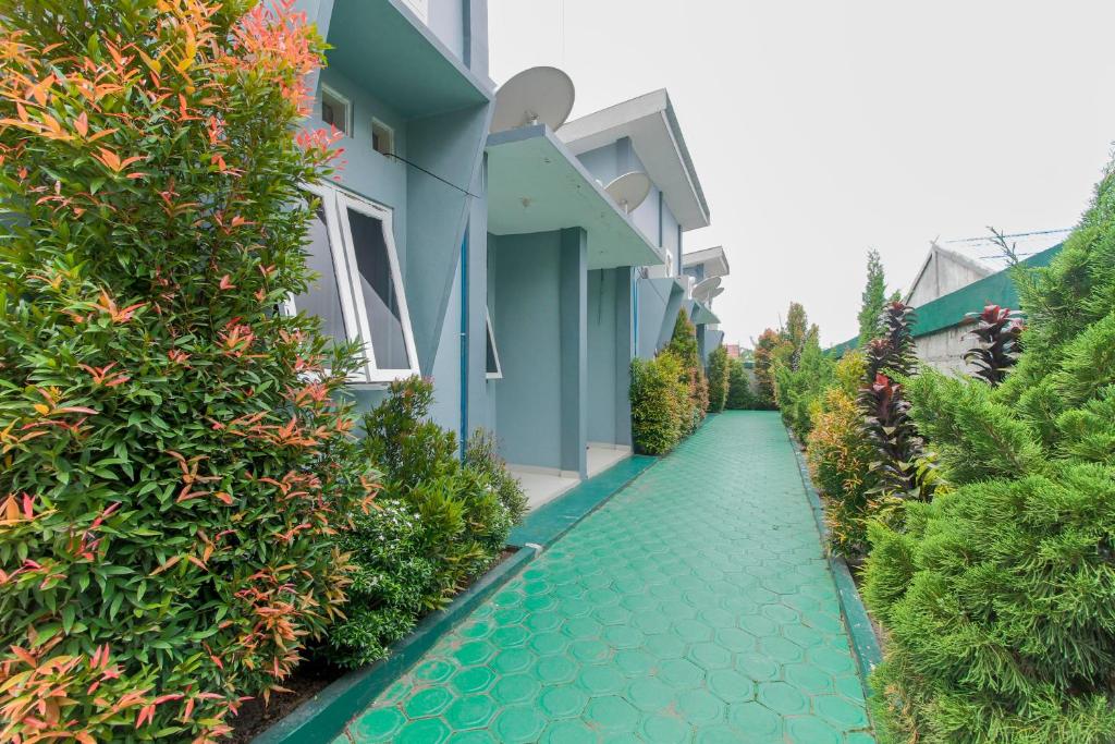 a pathway in front of a house with green plants at RedDoorz near Universitas Palangkaraya in Palangkaraya