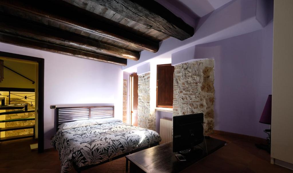 a bedroom with a bed and a desk and a television at Residenza Sant'Andrea in Campobasso