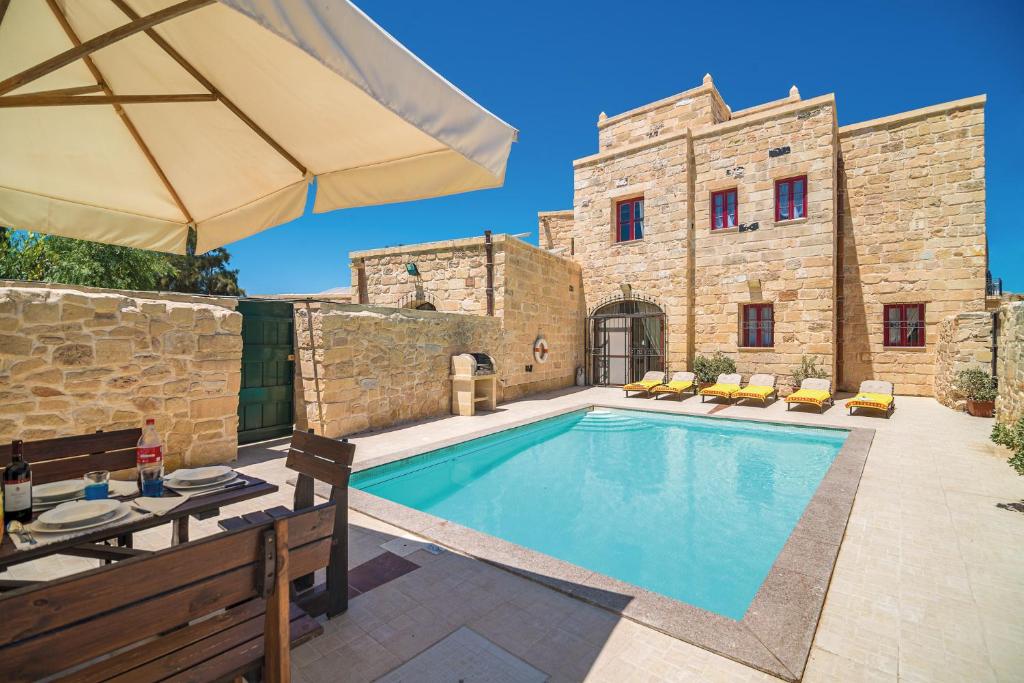 a villa with a swimming pool in front of a building at Villa Valletta in Żejtun