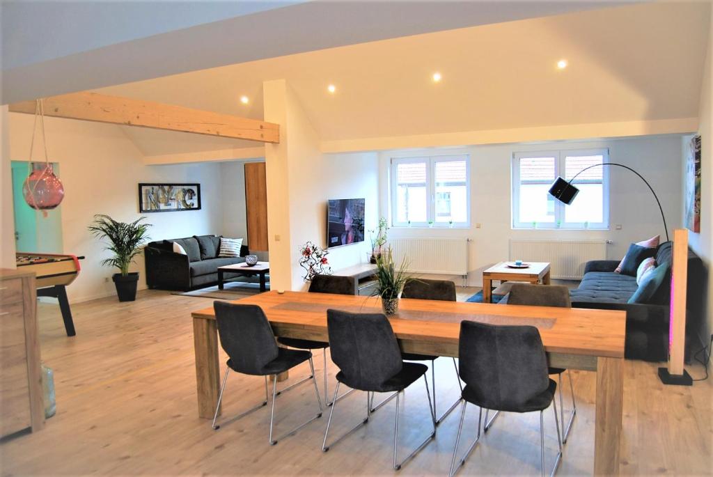ein Esszimmer und ein Wohnzimmer mit einem Tisch und Stühlen in der Unterkunft Luxus Loft ideal Europa Park, Straßburg und Schwarzwald in Friesenheim