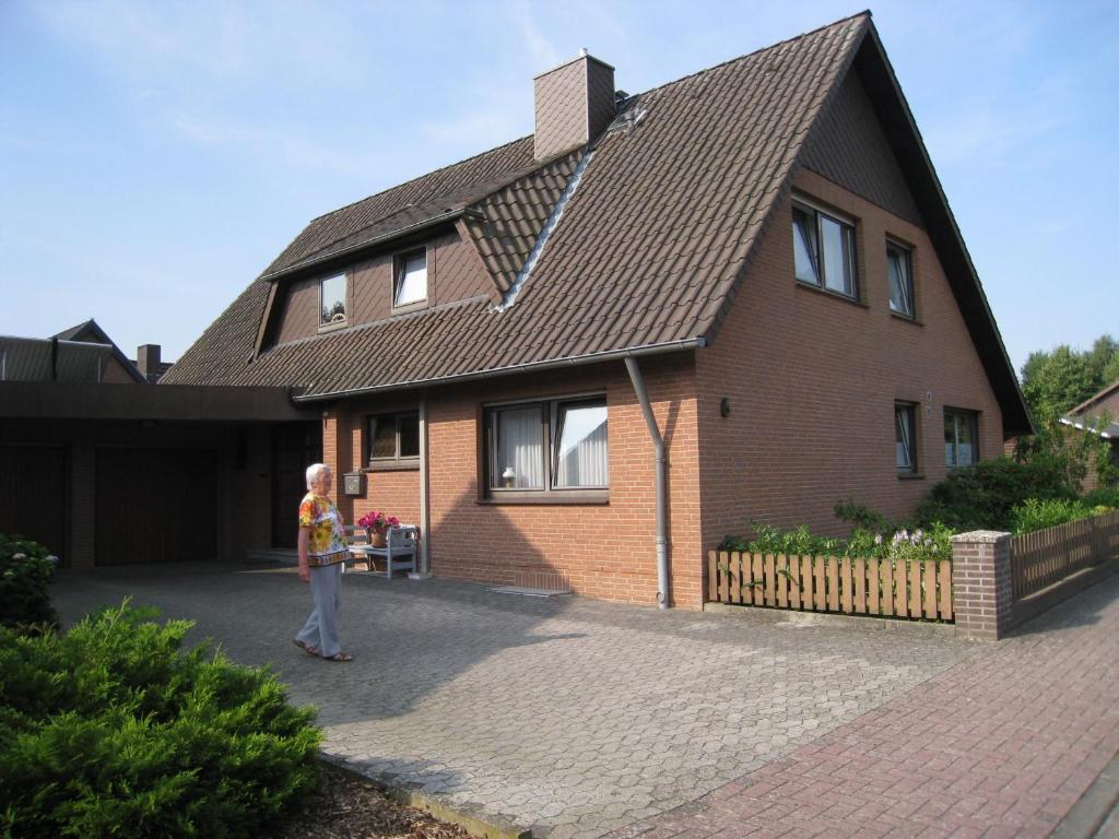 une jeune fille debout devant une maison dans l'établissement Meyer, à Soltau