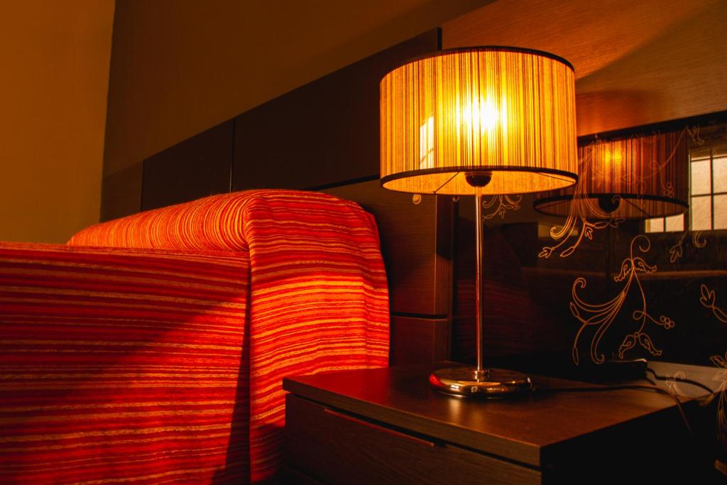 a bedroom with a bed and a lamp on a table at Hotel Cemar in Mondariz