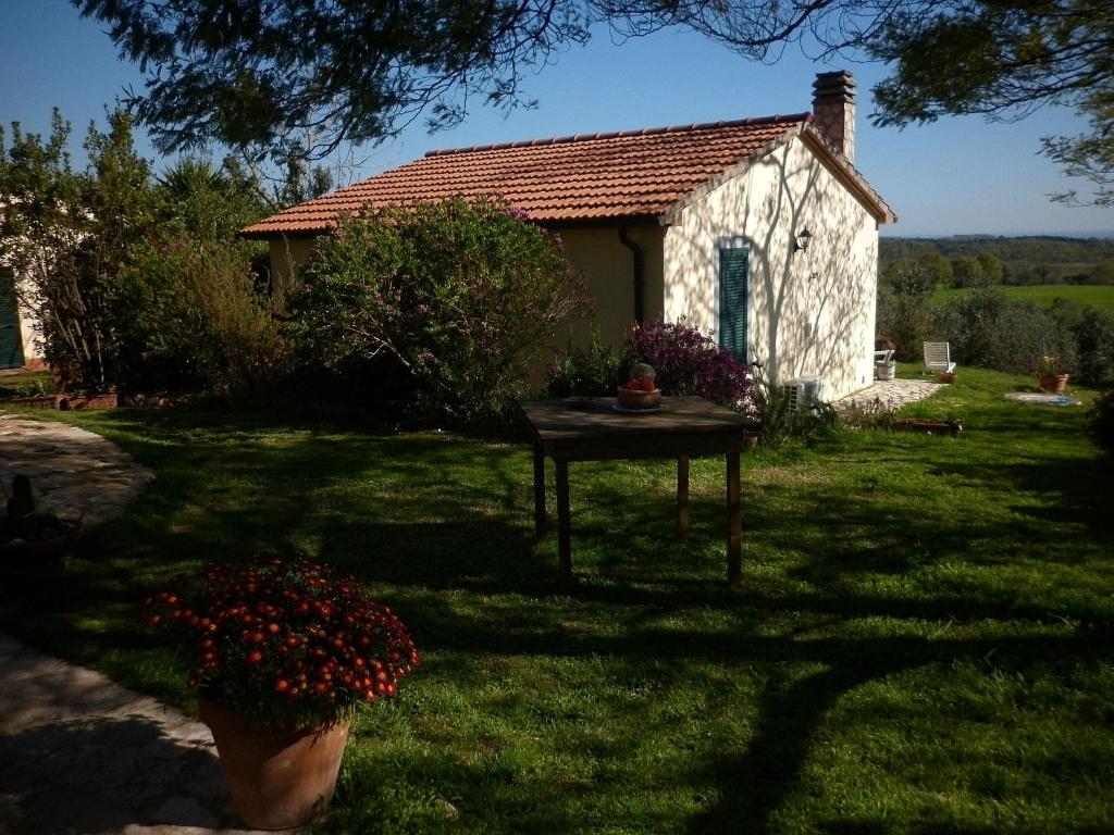 a small house with a table in the yard at Agriturismo le colline di Capalbio in Capalbio