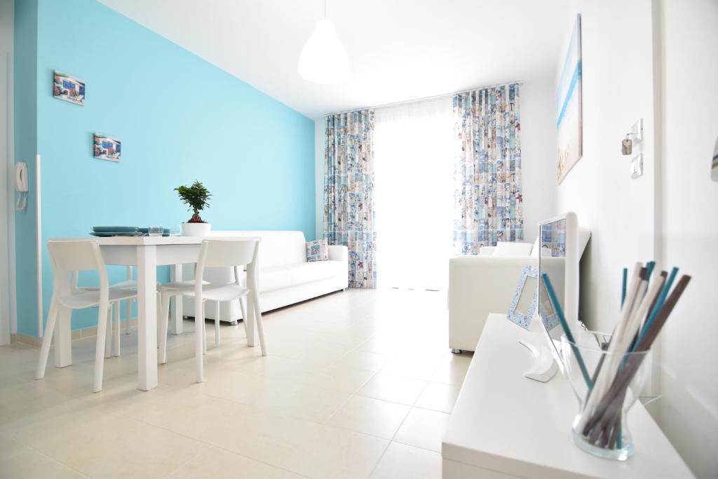 - une salle à manger blanche avec une table et des chaises blanches dans l'établissement La casa di Nadì, à Marina di Ragusa