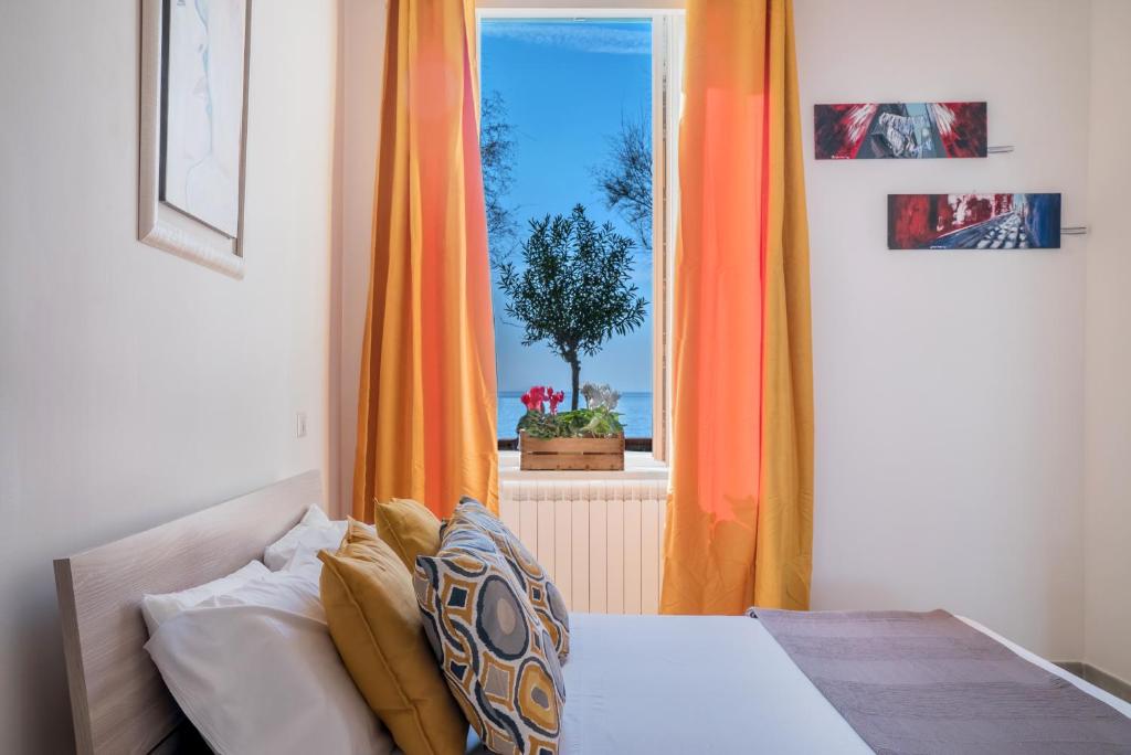 een slaapkamer met een oranje gordijn en een raam bij Accasarte P01 in Napels